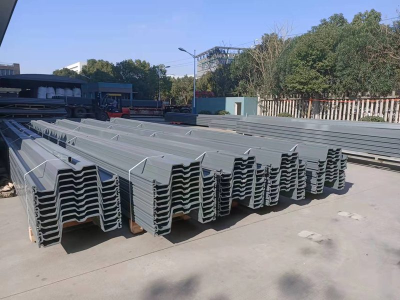 Real gray Z-profile PVC sheet piles stacked in separated bundles, with profile ends visible for delivery inspection.