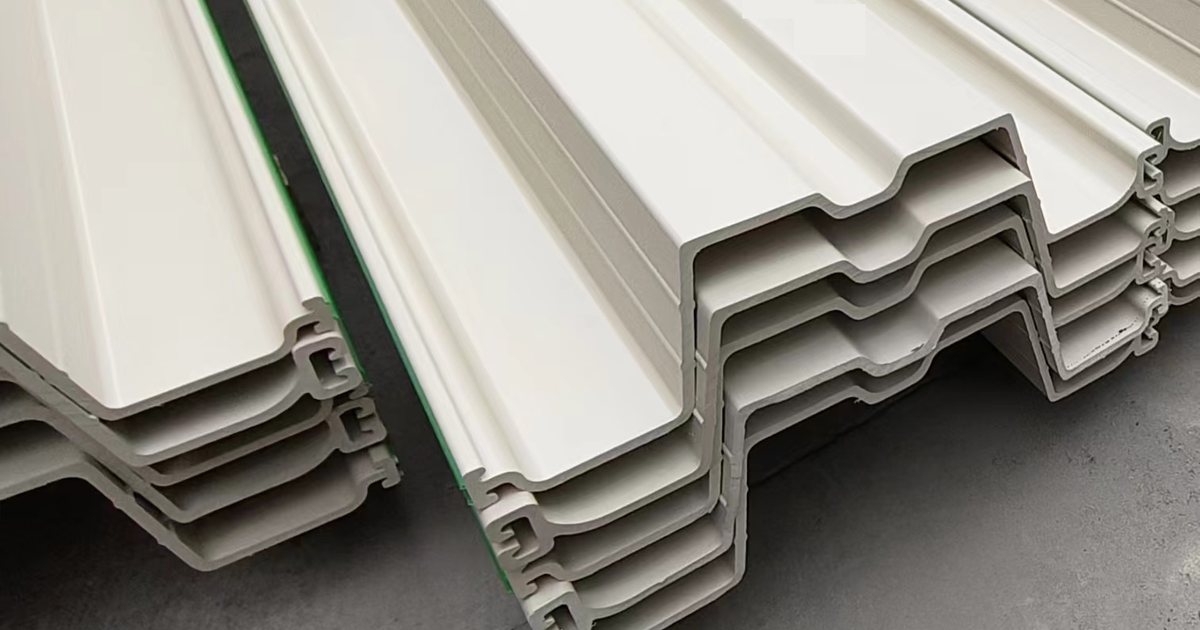 Light-colored PVC sheet pile profiles stacked in a clean bundle with the interlocking profile ends visible.