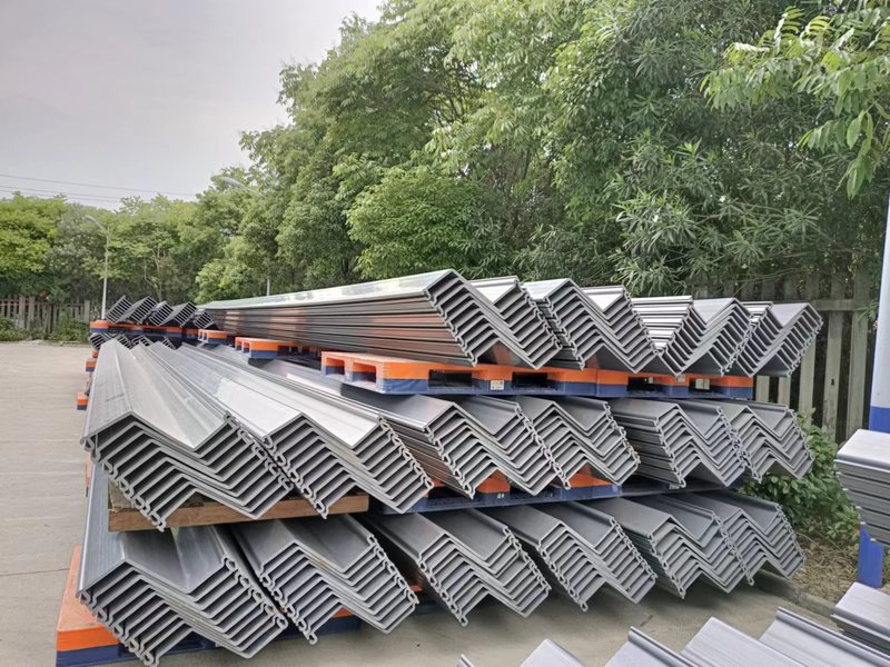 Light-colored PVC sheet pile profiles stacked in a clean bundle with the interlocking profile ends visible.
