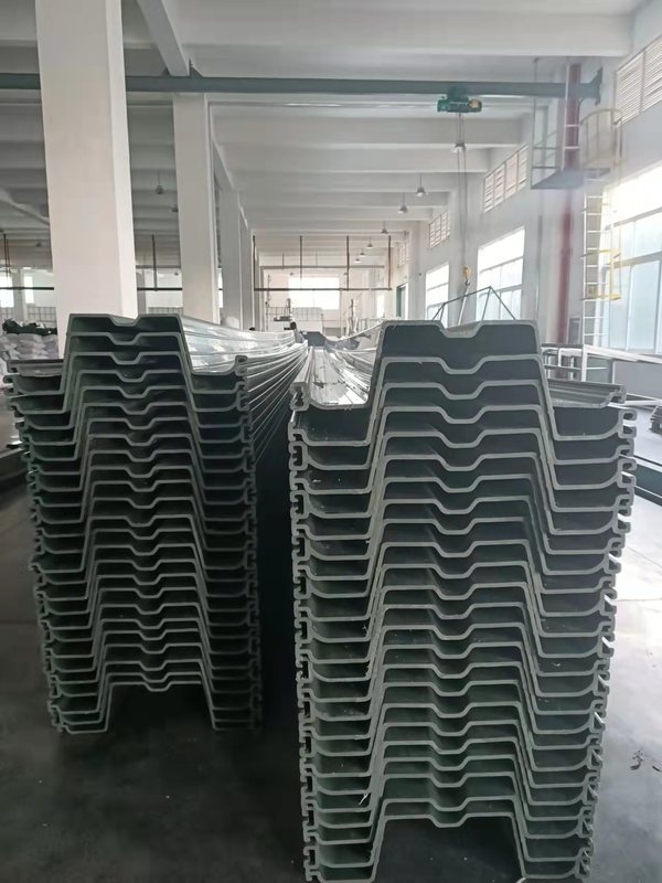 PVC sheet pile wall following the edge of a pond channel with water and vegetation beside the installation. PVC sheet pile wall following the edge of a pond channel with water and vegetation beside the installation.