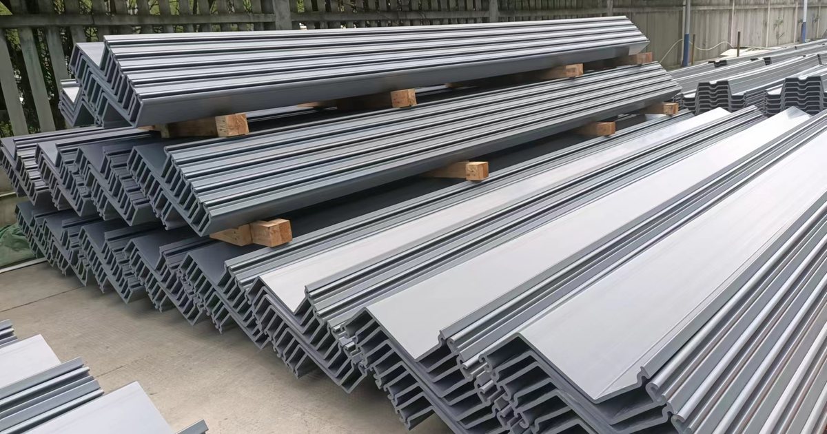 Gray PVC sheet pile profiles stacked on timber spacers with profile ends and interlocks visible.
