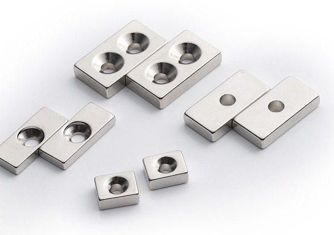 Nickel plated neodymium magnets in multiple shapes and sizes on a white background Nickel plated neodymium magnets in multiple shapes and sizes on a white background
